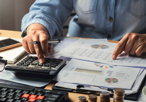 accounting concept. businesswoman working using calculator with money stack in office