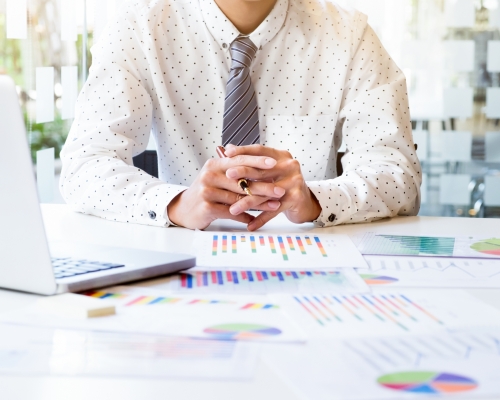 Startup businessman working with business documents on office table with graph financial diagram. Business idea concept.