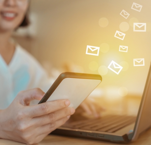Woman hand using laptop computer to send and recieve email for business on bokeh vintage color tone background.