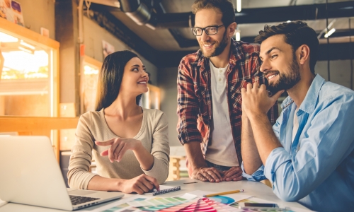 Designers in casual clothes is using a laptop.
